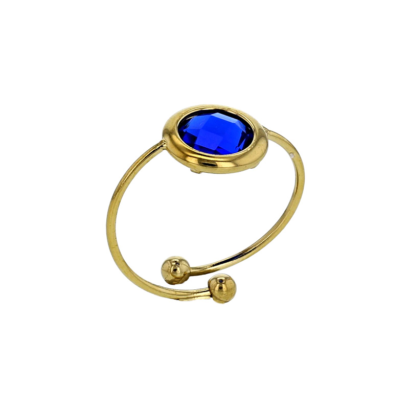 Bague réglable ornée d'un rond en verre facetté bleu marine, acier doré