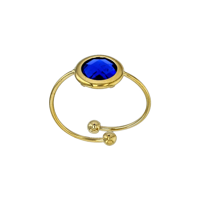Bague réglable ornée d'un rond en verre facetté bleu marine, acier doré