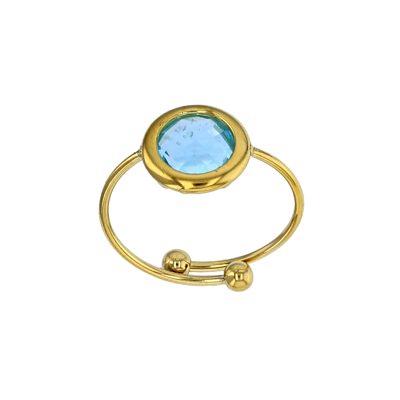 Bague réglable ornée d'un rond en verre facetté bleu marine, acier doré