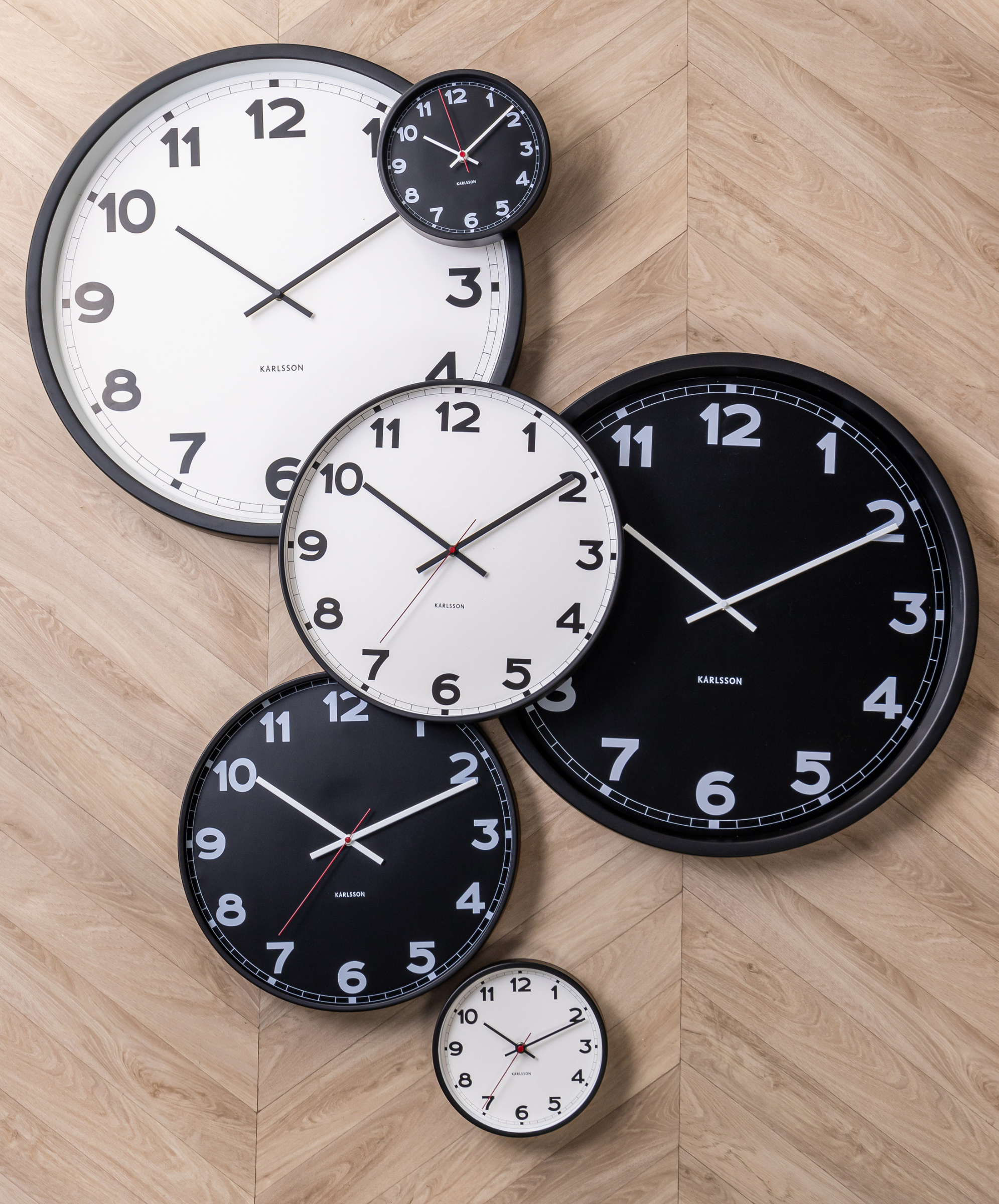 Horloge murale petit modèle métal, cadran noir, aiguilles blanches